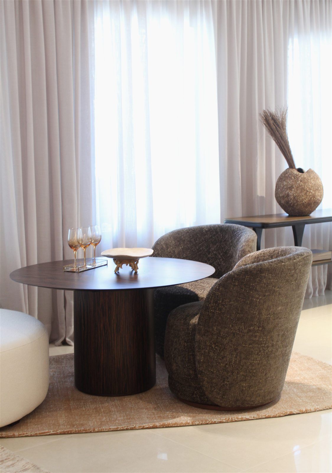 Ambiente com mesa de jantar e poltronas da Trinti